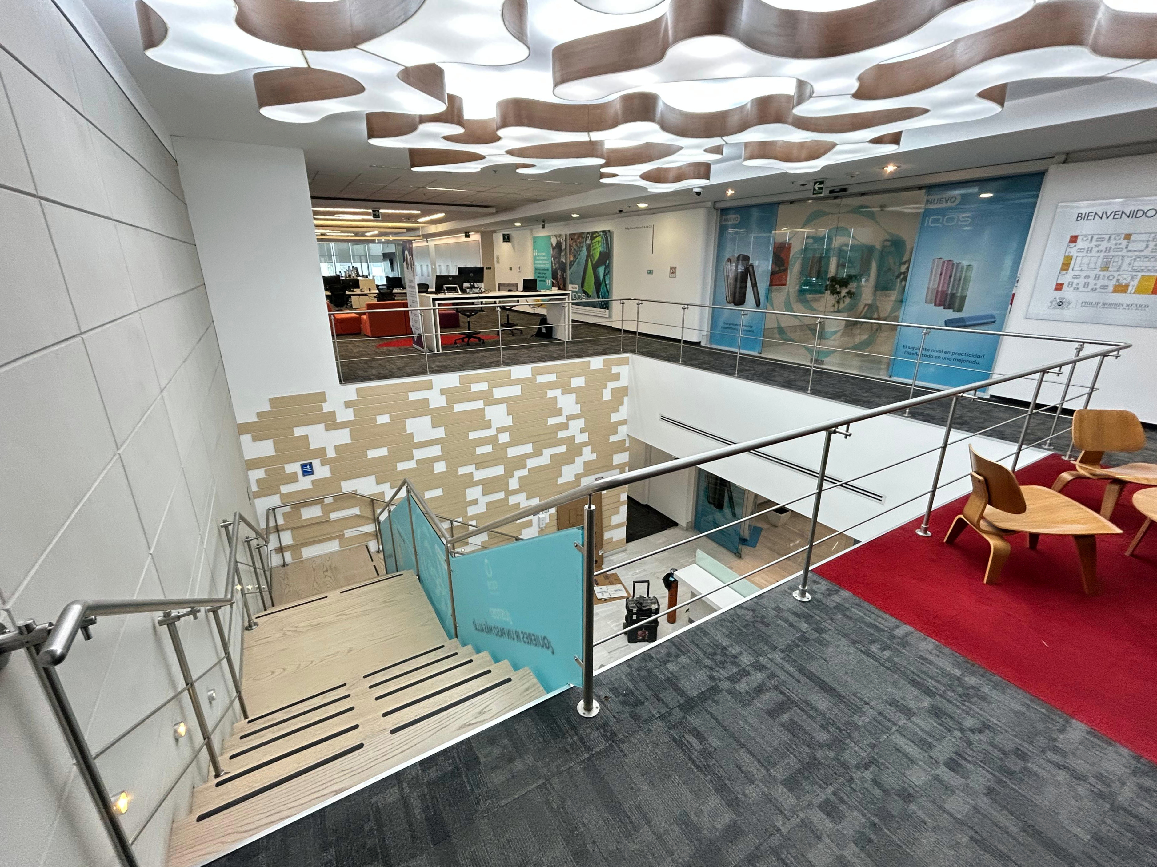 Barandal perimetral de acero inoxidable en mezzanine de oficinas corporativas en CDMX