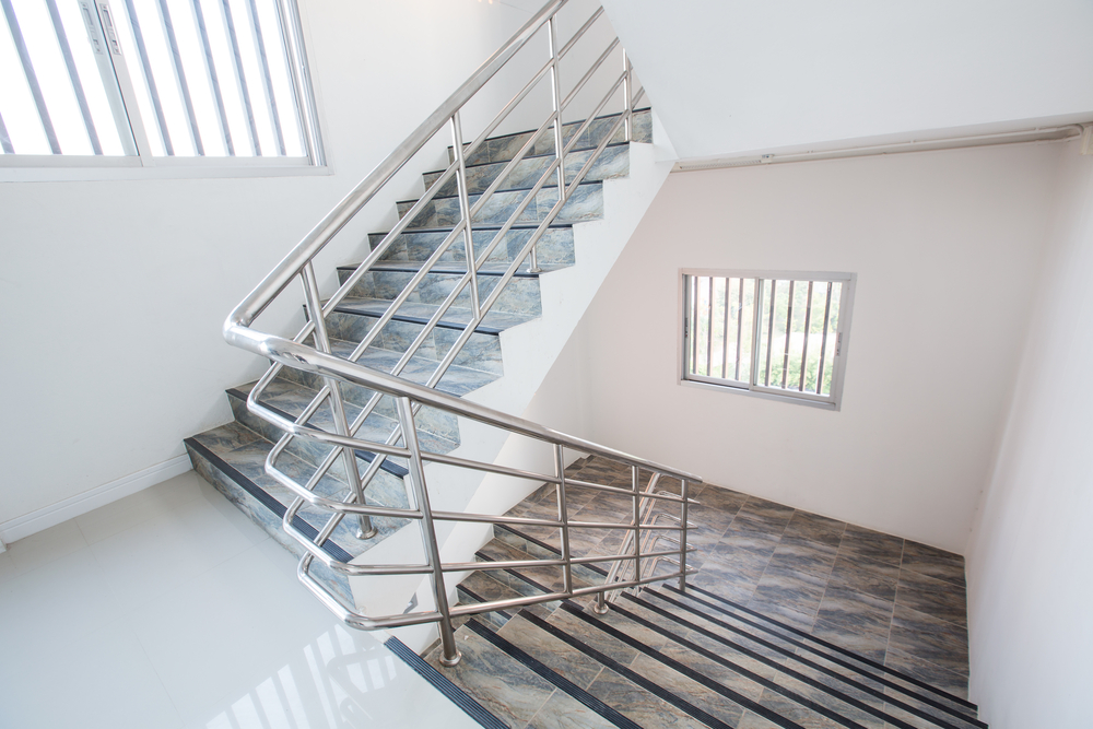 Barandal tubular de acero inoxidable instalado en escalera interior de vivienda