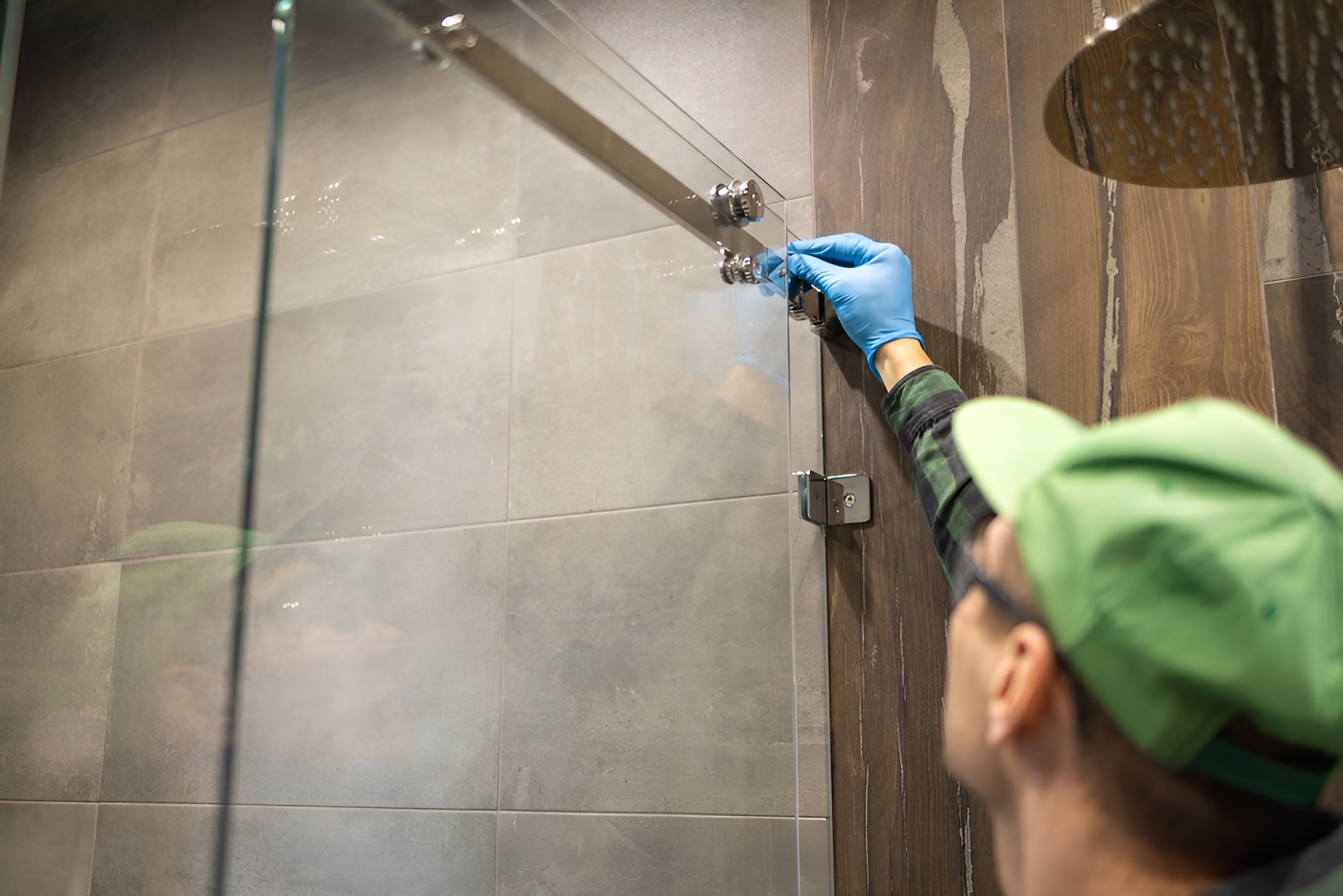 écnico ajustando cierre magnético en cancel de vidrio templado con herrajes de acero inoxidable