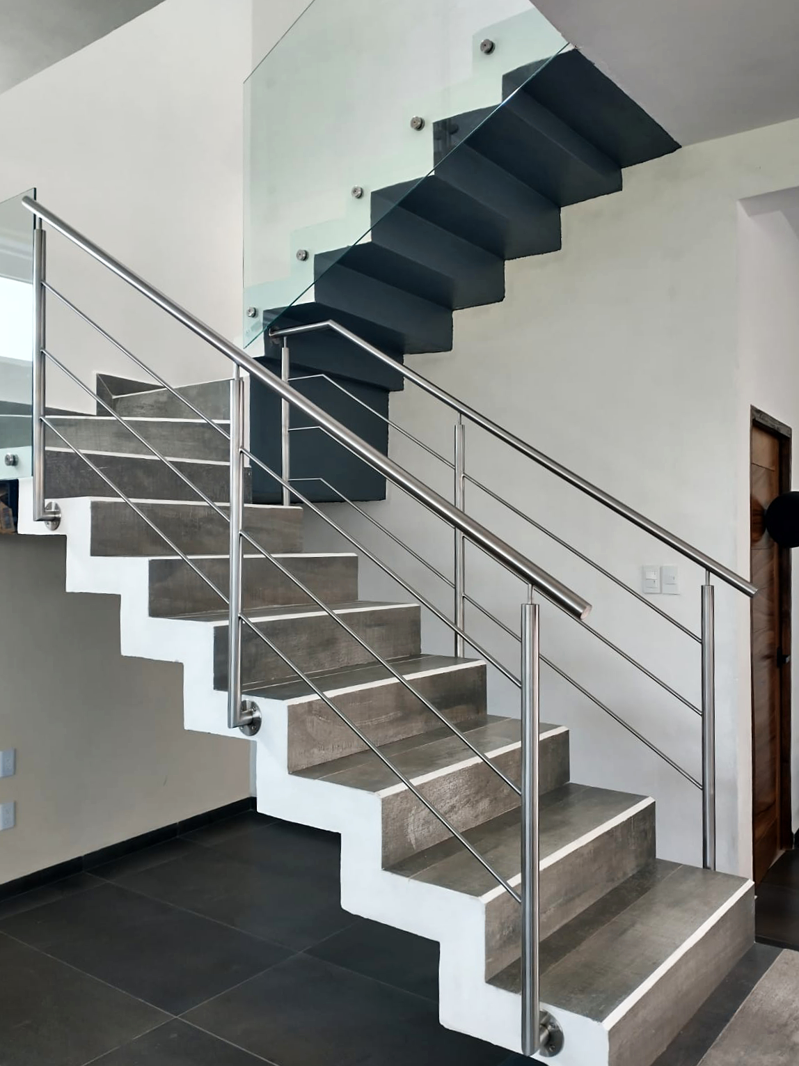 Escaleras en residencia moderna con barandal tubular inoxidable